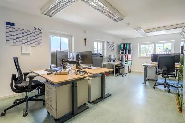 Das Büro von innen mit mehreren Bürotischen